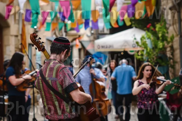 נגני רחוב מנגנים מוזיקת כליזמר מסורתית ביפו, ממדינת ישראל. גִ\'ינס, כלי נגינה, תַצלוּם