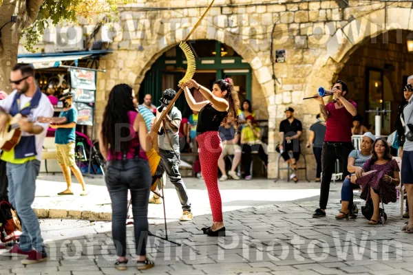 אמני רחוב משעשעים תיירים ביפו, ממדינת ישראל. מכנסיים, נַעַל, כלי נגינה