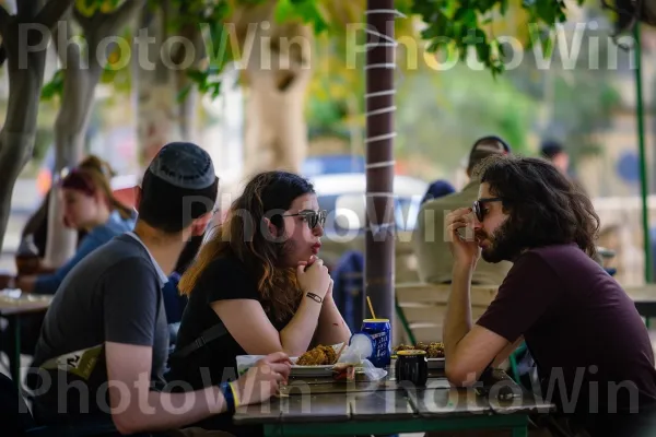 חברים נהנים מארוחת צהריים פלאפל בחיפה, שיחות ערות, ממדינת ישראל. שולחן, מישקפי שמש, פְּנַאִי