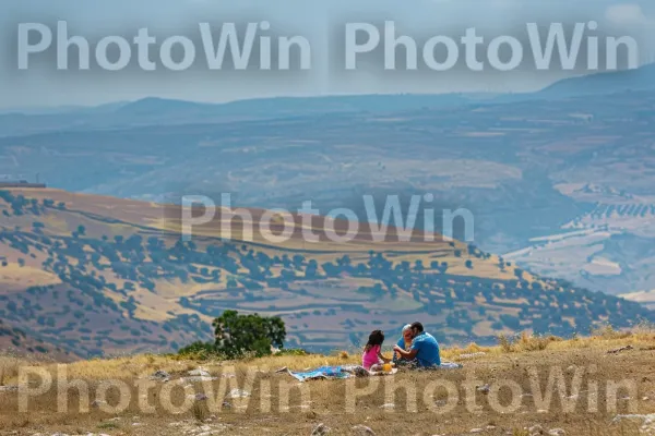 משפחה נהנית מפיקניק ברמת הגולן, ממדינת ישראל. שָׁמַיִם, קהילת צמחים, ענן