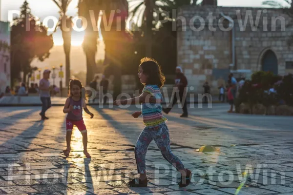 ילדים משחקים ברחובות חיפה בשקיעה, ממדינת ישראל. אוֹר, פְּנַאִי, כֵּיף