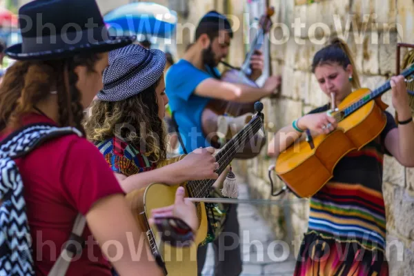 מוזיקאים באוטובוס בעיר העתיקה של צפת, ממדינת ישראל. תַצלוּם, כלי נגינה, כלי מיתר