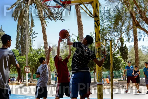 בני נוער משחקים כדורסל בפארק מקומי, ממדינת ישראל. שָׁמַיִם, כֵּיף, פְּנַאִי