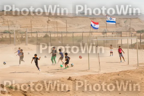 ילדים משחקים כדורגל במגרש משחקים מדברי נגב מאובק, ממדינת ישראל. אזור אקולוגי, נוֹפֶשׁ, שָׁמַיִם