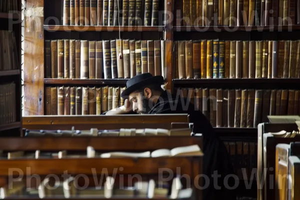 תלמידים הלומדים טקסטים עתיקים בספריית ישיבה, ממדינת ישראל. מדפים, כובע, סֵפֶר