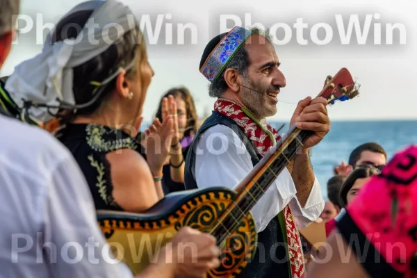 מוזיקאי מנגן מוזיקה מסורתית בפסטיבל חוף הים, ממדינת ישראל. כלי נגינה, כלי מיתר, אמנויות במה