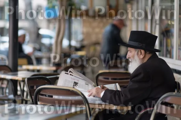 קשיש קורא עיתון בבית קפה בחיפה, ממדינת ישראל. כִּסֵא, כובע שמש, מוּסִיקָאִי