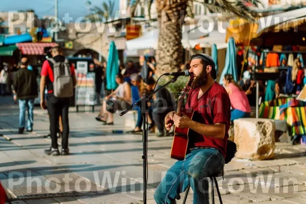 אמן רחוב מופיע מול צופים סקרנים ביפו, ממדינת ישראל. תַשׁתִית, מוּסִיקָאִי, כלי מיתר