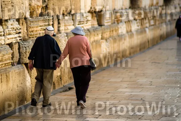 זוג מבוגרים הולך יד ביד, ממדינת ישראל. כובע, עוֹמֵד, מחווה