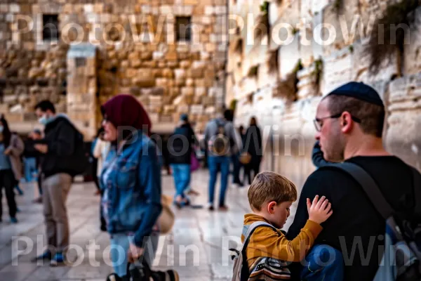 אב ובנו מתפללים בכותל המערבי בירושלים ממדינת ישראל. שְׁעוֹת הַיוֹם, בִּניָן, טיול