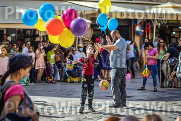 נגן רחוב משעשע המונים בתל אביב השוקקת, ממדינת ישראל. בן אנוש, צהוב, קבוצה חברתית