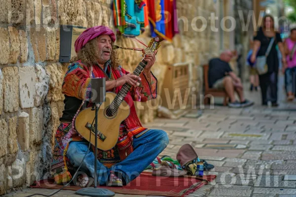 נגן רחוב משעשע תיירים ביפו, ממדינת ישראל. כלי נגינה, מוּסִיקָאִי, כלי מיתר