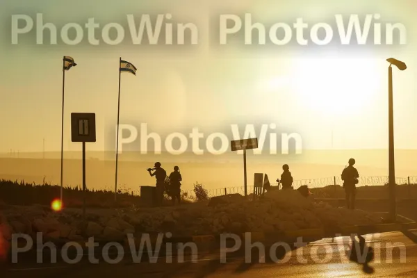 חיילים עומדים על המשמר במחסום, תחת שמש לוהטת ממדינת ישראל. זוהר לאחר, אוֹר שֶׁמֶשׁ, שקיעת החמה