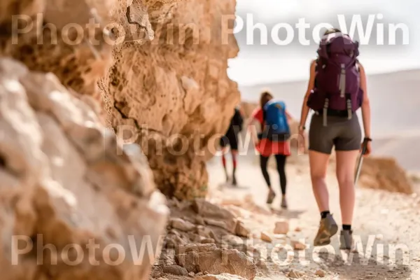 מטיילים חוקרים את חורבותיה העתיקות של מצדה, ממדינת ישראל. מִכְנָסַיִים קְצָרִים, גוף של מים, טיול