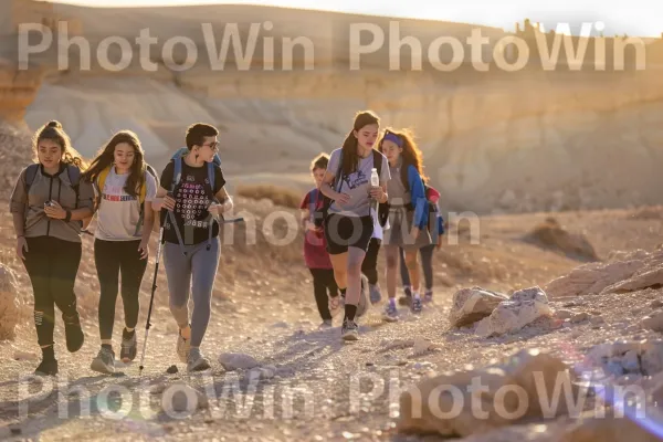 בני נוער מטיילים במדבר יהודה בזריחה, ממדינת ישראל. מִכְנָסַיִים קְצָרִים, מזוודות ותיקים, אנשים בטבע