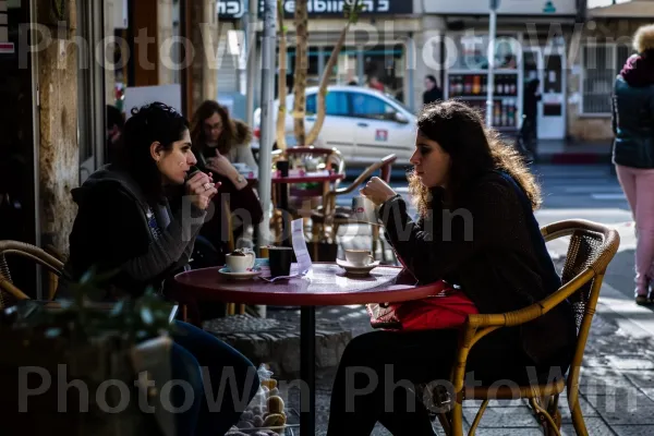 נשים מתרועעות בבית קפה, נהנות מקפה ושיחה, ממדינת ישראל. רְהִיטִים, עִיר, כלי שתייה