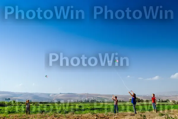 ילדים מעיפים עפיפונים בשדות בקעת הירדן, ממדינת ישראל. שָׁמַיִם, דֶשֶׁא, מישור