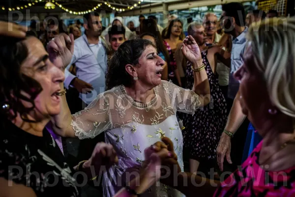 נשים רוקדות את ההורה בחתונה בטבריה, ממדינת ישראל. שיער, יד, שַׂמֵחַ