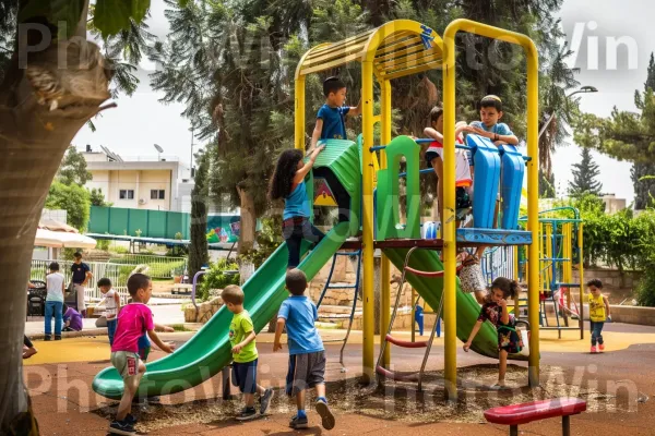 קבוצת תלמידי בית ספר משחקים בגן משחקים צבעוני ממדינת ישראל. ירוק, עֵץ, גן שעשועים