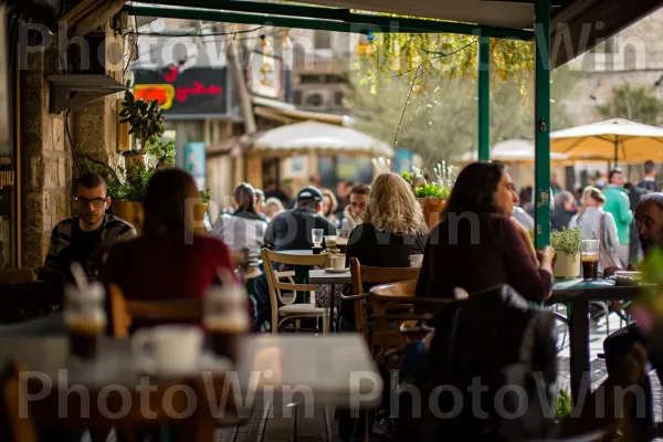 בתי קפה נעימים מלאים במקומיים לוגמים כוסות חזקות של קפה ישראלי, ממדינת ישראל. רְהִיטִים, צרכן, מרחב ציבורי