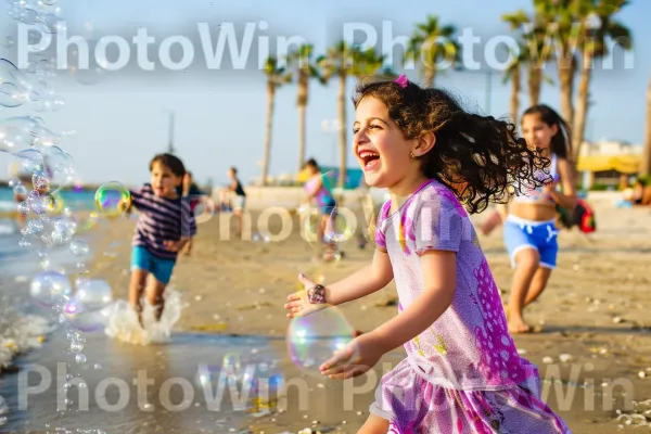 ילדים רודפים אחרי בועות בחוף תל אביבי ספוג שמש ממדינת ישראל. אנשים על החוף, אוֹר, ענן