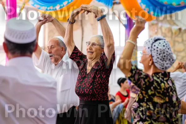 זוגות מבוגרים רוקדים את ההורה המסורתית בחגיגת חתונה ערה ממדינת ישראל. שַׂמֵחַ, צהוב, כֵּיף