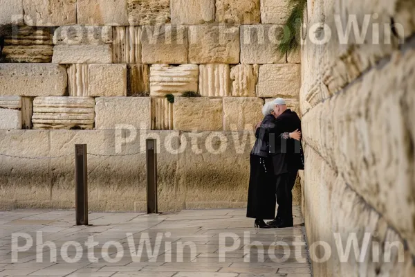 זוג מבוגרים מתחבקים בכותל, מתפללים בלהט ממדינת ישראל. בית המקדש, פני הכביש, רַצָפוּת