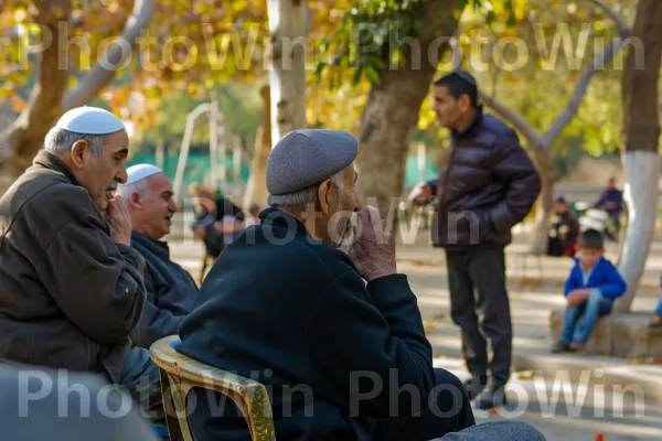 גברים מבוגרים עסקו בוויכוחים מונפשים בפארק מקומי, משמרים וחולקים חוכמה ממדינת ישראל. עֵץ, כובע, נוֹפֶשׁ