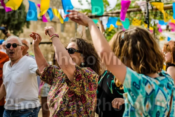 אנשים נהנים ממוזיקה יהודית מסורתית וריקודים בפסטיבל תוסס, ממדינת ישראל. יד, משקפיים, מישקפי שמש