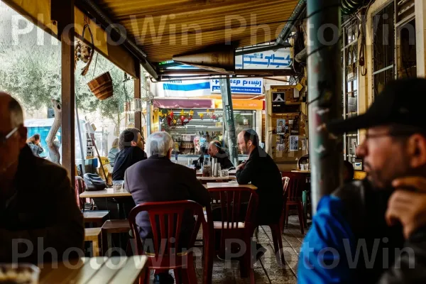 ויכוח ער בין חברים בבית קפה ירושלמי שוקק חיים, ממדינת ישראל. צהוב, בִּניָן, עִיר