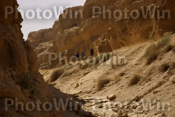 קבוצת חברים מטיילת בנופים עוצרי הנשימה של מצדה, ממדינת ישראל. סלע יסוד, צורות קרקע הרריות, היווצרות