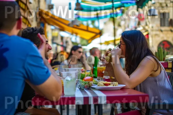 חברים נהנים מארוחת פלאפל טעימה, מתענגים על הטעם של ישראל, ממדינת ישראל. מזון, שולחן, כלי שולחן