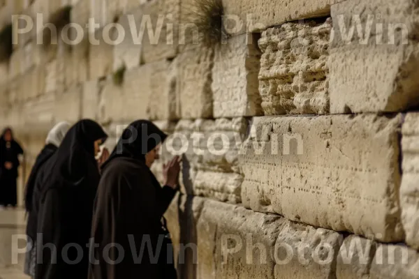 קבוצת נשים מתפללות בכותל מוצאות נחמה במסירות נפש, ממדינת ישראל. לְבֵנָה, לבנים, עץ