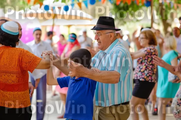 זקנים וצעירים רוקדים את ההורה במהלך חגיגת יום העצמאות הישראלי חגיגי ממדינת ישראל. כובע, סָגוֹל, כתום