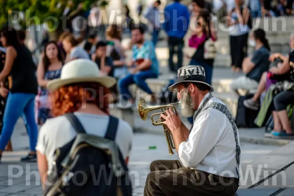 נגן רחוב משעשע את העוברים והשבים במוזיקת כליזמרים מסורתית, ממדינת ישראל. כלי נגינה, כובע, פדורה