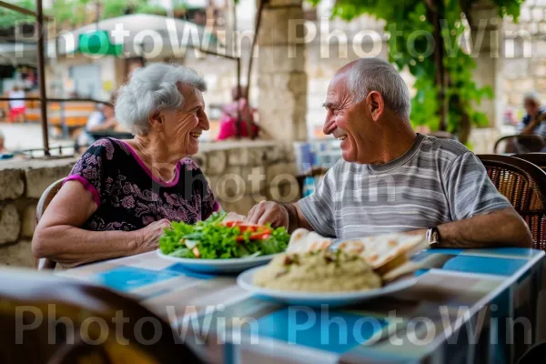 זוג מבוגרים חולקים ארוחת פלאפל וחומוס בבית קפה תל אביבי נעים, ממדינת ישראל. כִּסֵא, מִטְבָּח, שיתוף