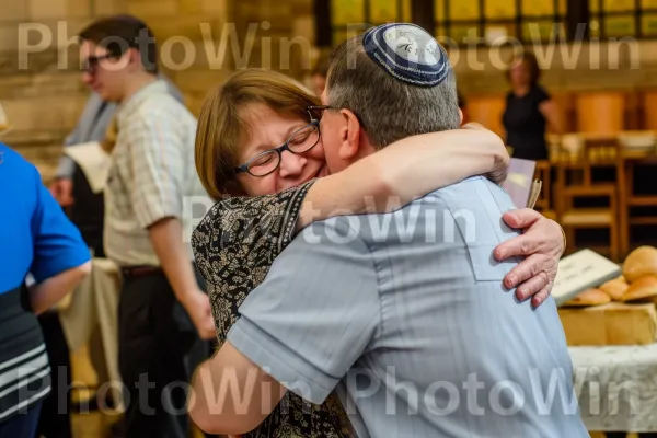 הורים גאים מחבקים את ילדם בחגיגת בר מצווה. חיוך, פְּנַאִי, חולצה קצרה