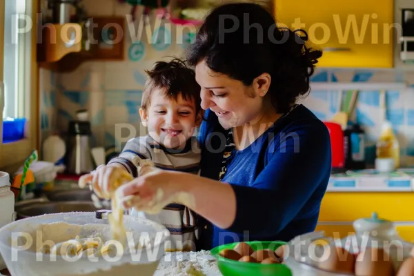 אמא מדריכה את בנה באומנות הכנת פסטה מאפס. מזון, חיוך, שיתוף