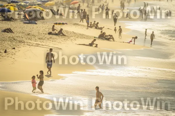 סצנת חוף שלווה עם אנשים העוסקים בפעילויות חוצות. תַצלוּם, אנשים על החוף, גוף של מים