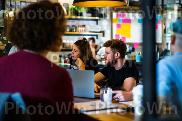 יזמים צעירים דנים ברעיונות חדשניים בבית קפה. שולחן, חולצה קצרה, מַחשֵׁב