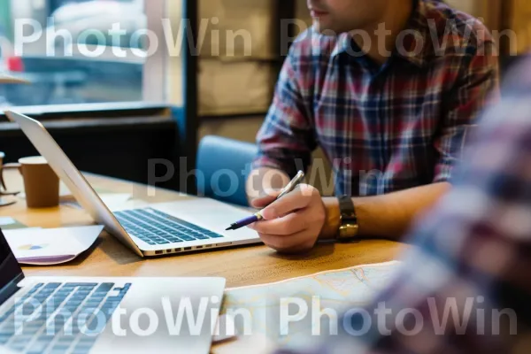 איש עסקים דן באסטרטגיות עם מנטור בבית קפה. שעון, מחשב נייד, כלי שולחן