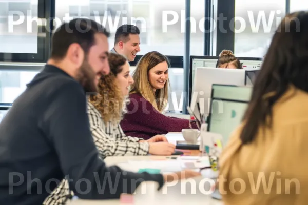 סביבת מקום עבודה דינמית המציגה עבודת צוות וסינרגיה. חיוך, מַחשֵׁב, שולחן